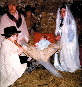 Levende kerststal Monique Smeets met blokfluit. Jozef, Frans Nevels, Maria, mevr. Jose Ubachs en Armond Meijers als herder.  Het levende kerstkindje werd afgestaan door het echtpaar Ubachs- Haerden. Noodkerkje Hettekensweg 1983.