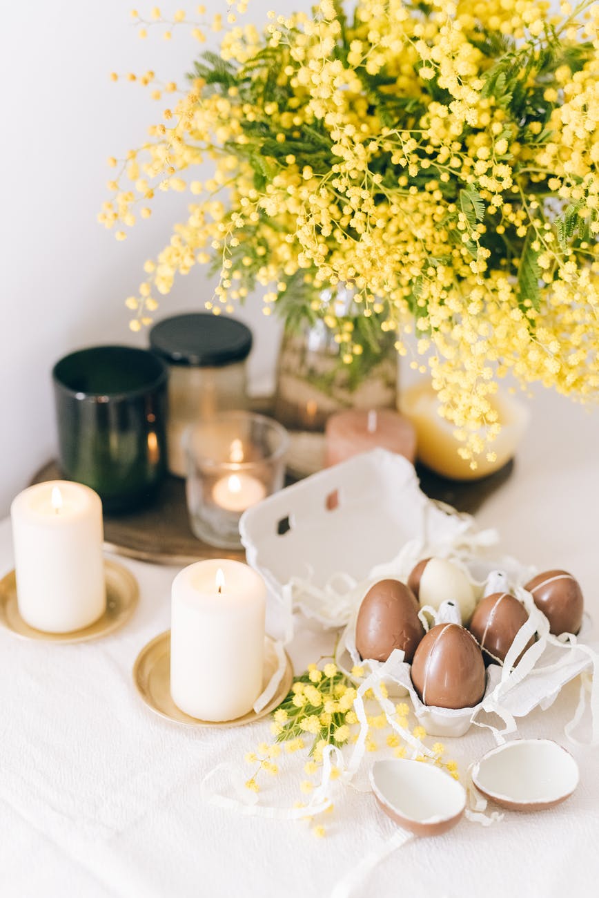 colored eggs and burning candles on table